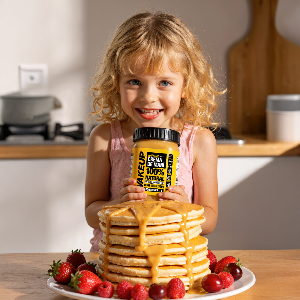 Niña feliz con pancakes y crema de maní WAKEUP en desayuno nutritivo