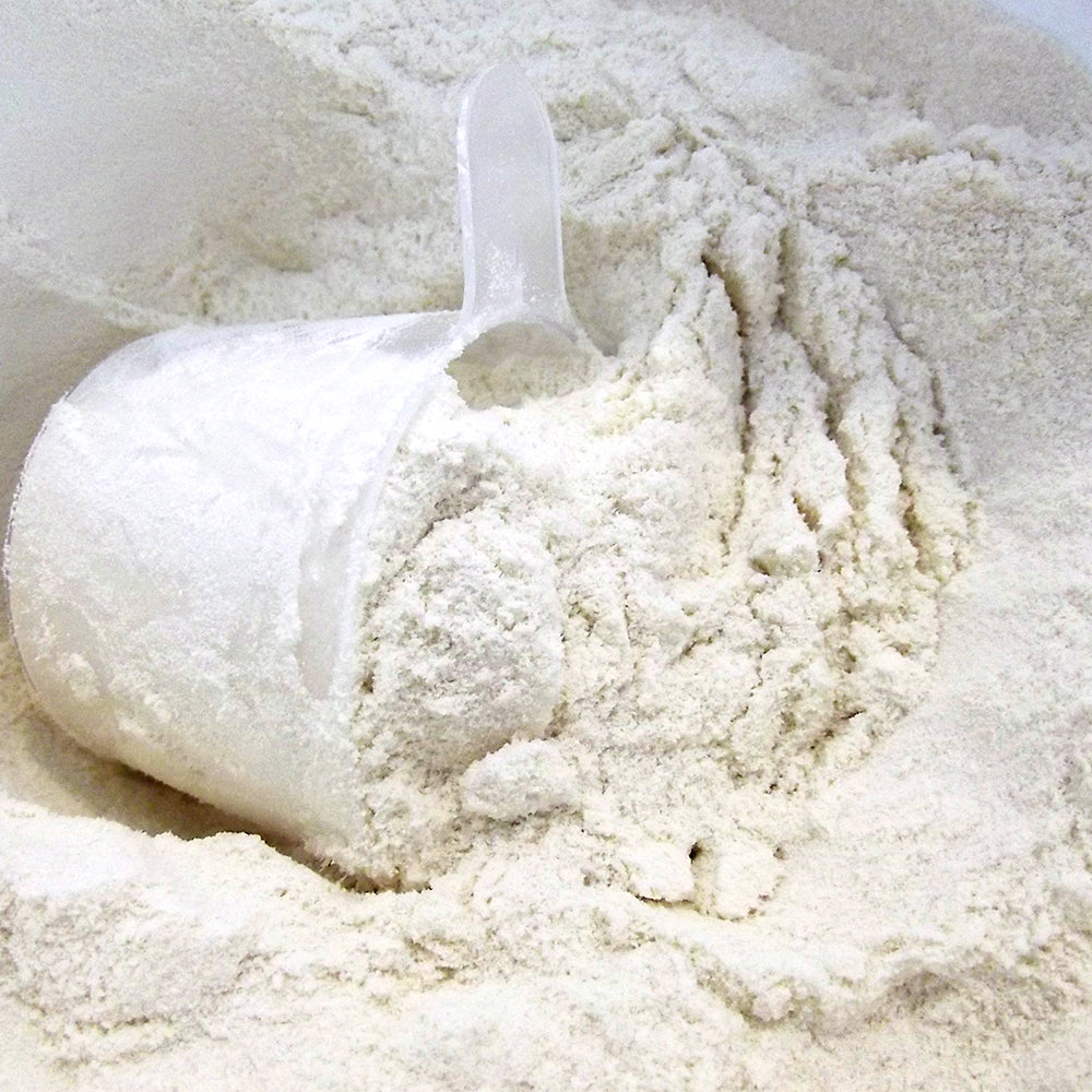 Proteína WAKEUP vainilla en polvo, textura blanca aireada en fondo neutro