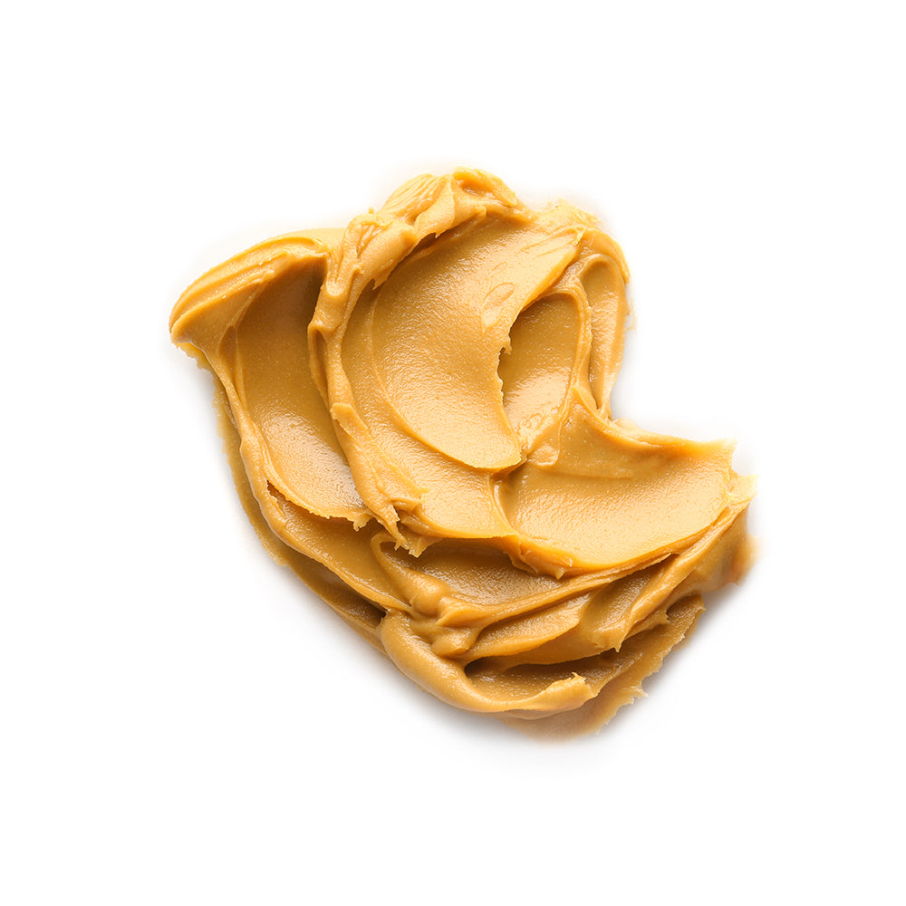 Crema de maní natural WAKEUP untada sobre fondo blanco, textura suave, sin aditivos
